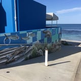 The mural features land-based information and safety signage. 